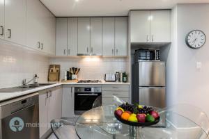 a kitchen with a bowl of fruit on a glass table at Redfern One Bedroom Apartment with Views in Sydney