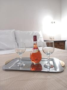 a tray with a bottle and two glasses on a bed at Coastal Dream Apartments in Keramoti