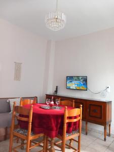 a dining room with a red table and chairs at Coastal Dream Apartments in Keramoti