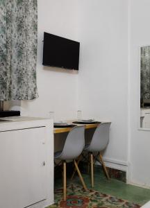 - un bureau avec deux chaises et une télévision murale dans l'établissement Casa Paxi, à Mérida