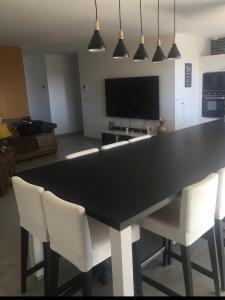 a black table with white chairs in a living room at Maison entière haut standing in Mignaloux-Beauvoir +19 photos