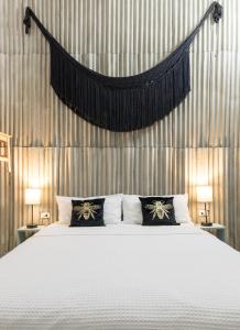 une chambre avec un grand lit blanc avec deux lampes dans l'établissement Casa Paxi, à Mérida