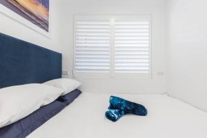 a bed with a shoe sitting on top of it at Bondi Beach Spacious Apartment in Sydney +8 photos