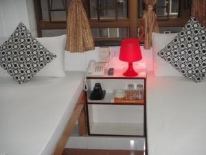 una lámpara roja en una mesa pequeña en una habitación en Paris Guest House, en Hong Kong