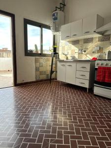 a kitchen with a tiled floor and white cabinets at Casa Ciao in Deán Funes +3 photos