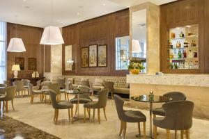 a restaurant with tables and chairs and a bar at Windsor Marapendi Hotel in Rio de Janeiro
