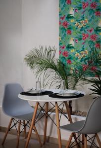 une table avec deux chaises et une table avec une plante dans l'établissement Casa Paxi, à Mérida