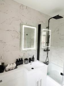 uma casa de banho branca com um lavatório e uma banheira em Beautiful apartment in Beckton with Private Entrance and Garden em Londres