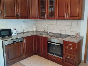 a kitchen with wooden cabinets and a sink at Pelivan Apartments in Kaštela