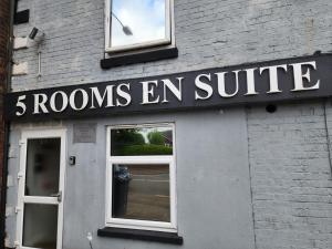 a building with a sign that reads rooms en suite at THE NEW INN Newton Derbyshire in Tibshelf