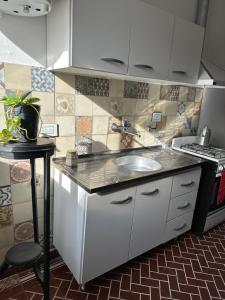 a kitchen with a sink and a stove at Casa Ciao in Deán Funes