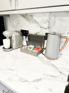 a white counter top with a coffee maker and a cup at Beautiful apartment in Beckton with Private Entrance and Garden in London