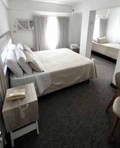 um quarto de hotel com uma cama grande e uma mesa em Hotel Plaza Formosa em Formosa