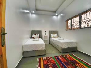 1 Schlafzimmer mit 2 Betten und einem Fenster in der Unterkunft Villa Charfa Élégance Confort et Vues Panoramiques in Essaouira