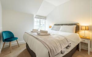 ein Schlafzimmer mit einem großen Bett und einem blauen Stuhl in der Unterkunft Loughrigg in Ambleside