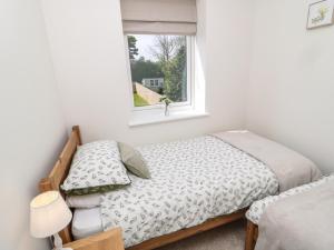 Schlafzimmer mit einem Bett und einem Fenster in der Unterkunft The Miners Cottage in Berwick-Upon-Tweed