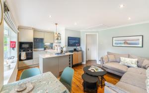een keuken en woonkamer met een bank en een tafel bij Lowera Cottage in Windermere +10 foto's