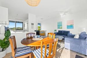 a living room with a table and chairs and a couch at 4-53 Forsters Bay Road, Narooma - Blue Water Villas in Narooma +11 photos