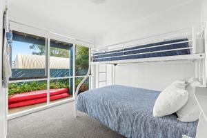 a bedroom with a bed and a large window at 4-53 Forsters Bay Road, Narooma - Blue Water Villas in Narooma