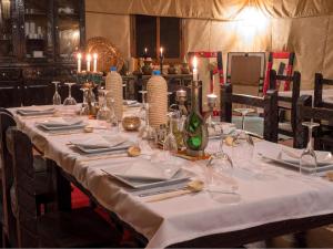 einen Tisch mit einem weißen Tischtuch und Kerzen darauf in der Unterkunft Services Luxury Camp in Merzouga