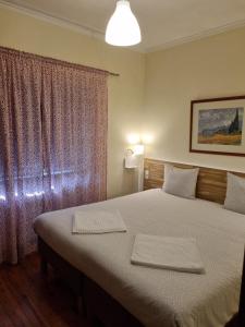 Margarida Guest House - Rooms في ألمادا: غرفة نوم بسرير كبير ونافذة