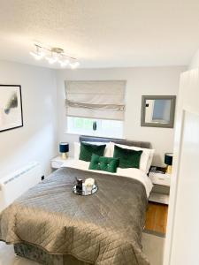 1 dormitorio con 1 cama grande con almohadas verdes en Beautiful apartment in Beckton with Private Entrance and Garden, en Londres