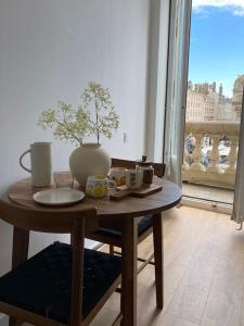 una mesa con un plato y un jarrón. en Balcon Place des Terreaux, en Lyon