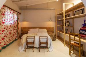 a bedroom with a bed and two chairs at Casa Bernardina in Tilcara