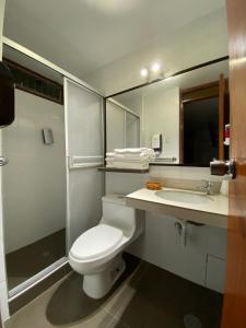 Łazienka z białą toaletą i umywalką w obiekcie Hotel America Chiclayo w mieście Chiclayo