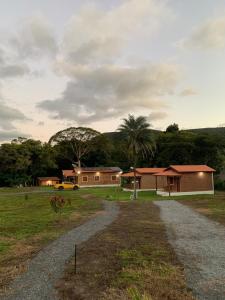 una casa con un camino de grava al lado de un campo en Chalé Quartzo no Recanto Diamantina entre Palmeiras e Capão, en Palmeiras