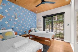a bedroom with two beds and a blue wall at Coolum Scenic Getaway - Mountain & Ocean views only 15 minutes from the beach in Yandina Creek +7 photos