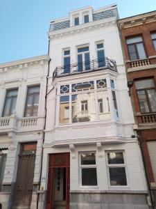 a white building with a balcony on top of it at Stay in Artist’s Gallery in Antwerp +2 photos