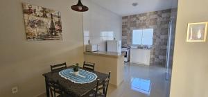 une cuisine et une salle à manger avec une table et des chaises dans l'établissement Casa Duplex Esperança - Ar e Garagem Privativa, à Bom Jesus da Lapa