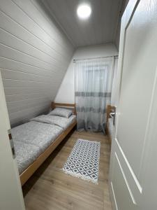 um pequeno quarto com uma cama e um tapete em Vikendice Ana em Žabljak