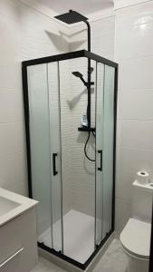 La salle de bains est pourvue d'une douche en verre et de toilettes. dans l'établissement Casa do Vale, à Portimão
