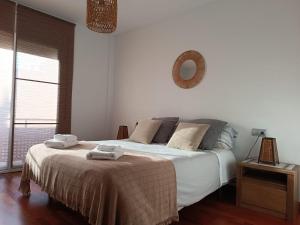 a bedroom with a bed with two towels on it at Apartamento Plaza de la Iglesia in Deltebre