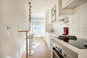 a kitchen with white appliances and a counter top at Sunny - Cozy Apartment in Amadora