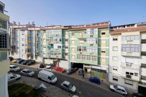 a city street with cars parked in front of buildings at Sunny - Cozy Apartment in Amadora