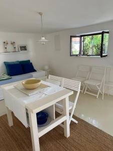 a white living room with a table and chairs at Apartmani Krk in Krk