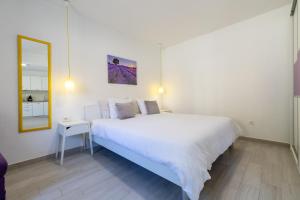- une chambre blanche avec un grand lit et un miroir dans l'établissement Apartments with a parking space Hvar - 22023, à Hvar