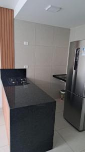 a kitchen with a black counter top and a refrigerator at Edificio Nau no coração da Barra in Salvador