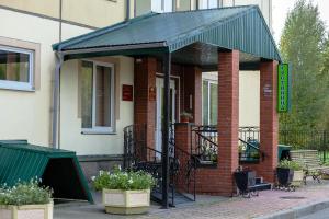 a brick building with a green awning on it at Hotel Ingriya in Kolpino