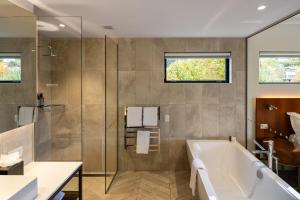 a bathroom with a tub and a glass shower at Queenstown Park Boutique Hotel in Queenstown +37 photos