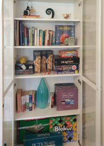 Rosebank Guesthouse في هيلسفيل: رف للكتب مليء بالكتب و مزهرية زرقاء