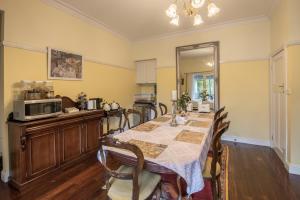 uma sala de jantar com uma mesa e um micro-ondas em Rosebank Guesthouse em Healesville