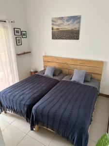 een bed met een blauw dekbed in een slaapkamer bij El Chante Surf House in Santa Teresa Beach