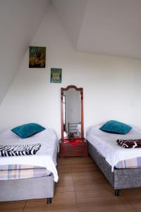 a bedroom with two beds and a mirror at Paraiso de la sierra in Santa Marta