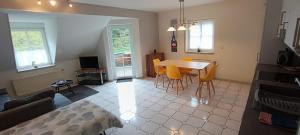 ein Wohnzimmer mit Tisch, Stühlen und Sofa in der Unterkunft Narzisse 3-4 Personen - Ferienwohnungen Wagner & Gaul Falkenauel in Falkenauel