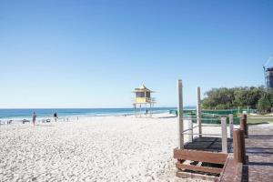 a beach with a life guard tower and people on the beach at Oracle 2 1907 in Gold Coast