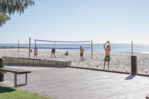 a group of people playing volleyball on the beach at Oracle 2 1907 in Gold Coast